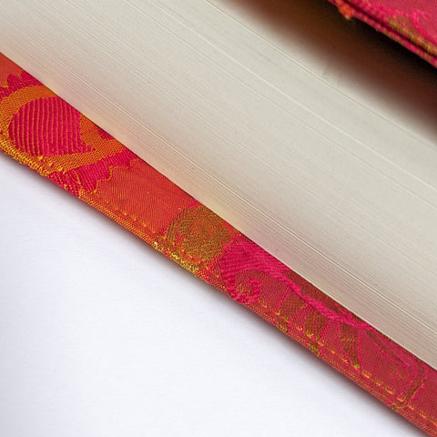 Book with red and gold decorative cover on a white background