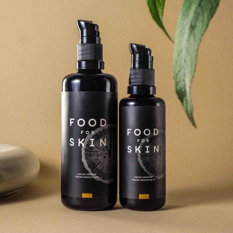 50 ml en 100 ml Carrot Cleanser naast elkaar met bruine achtergrond