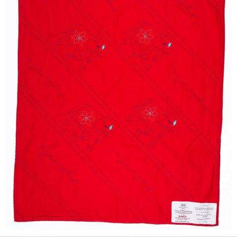 Red quilt with diamond pattern on a white background