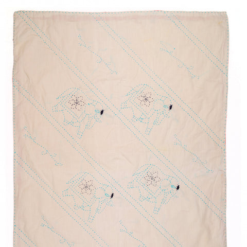 Beige quilt with embroidered patterns on a white background