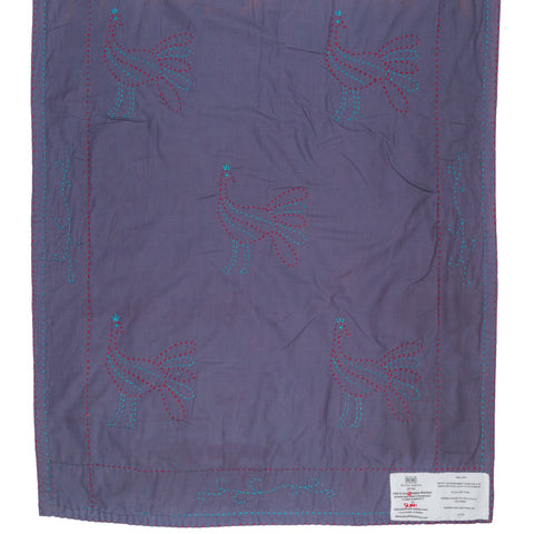 Purple fabric with embroidered designs on a white background