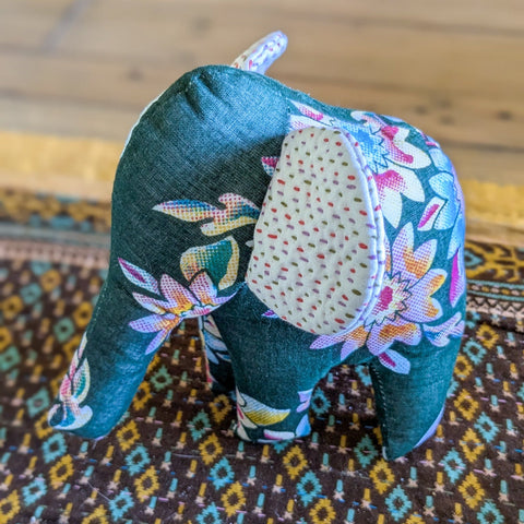Decorative fabric elephant on a patterned rug
