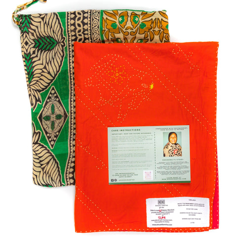 Orange fabric with labels and a green and gold patterned bag on a white background