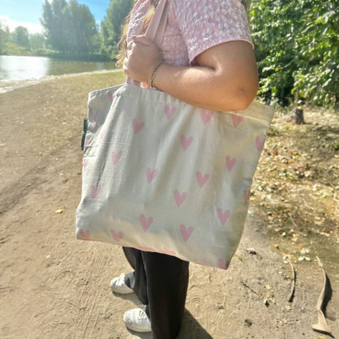 Duurzame tas gerecycled katoen met roze hartjes sfeerfoto strand