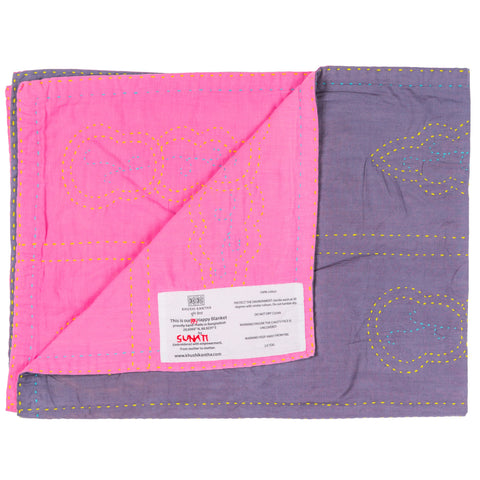 Pink and purple quilt with visible brand label on a white background