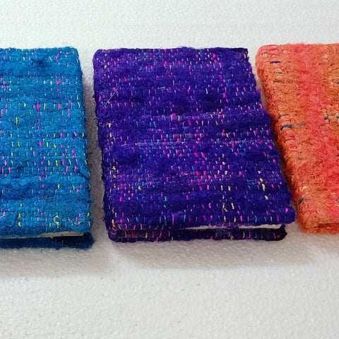 Colorful textured books arranged in a row on a white surface