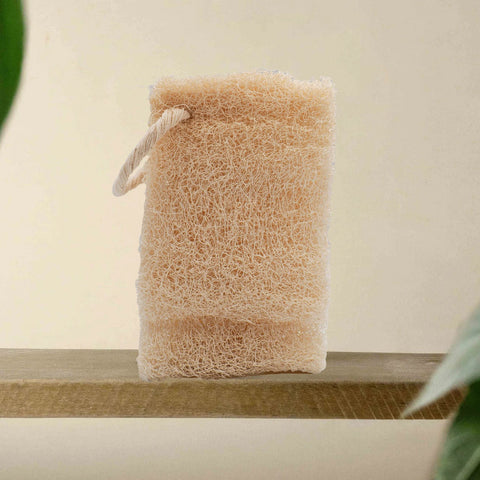 Loofah spons op houten plankje in badkamer setting voor natuurlijke huidverzorging