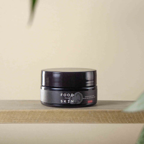 Food for Skin natuurlijke dag- en nachtcrème pot op houten plank met zachte achtergrond
