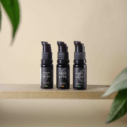 Drie verschillende serums in proefset op houten plankje