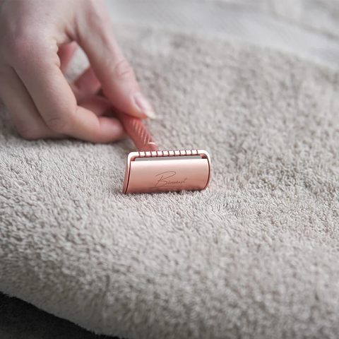 Safety razor rose gold op lichtbruine handdoek.