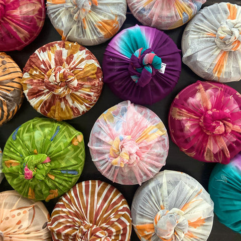 Colorful fabric gift wrapped items arranged on a dark surface
