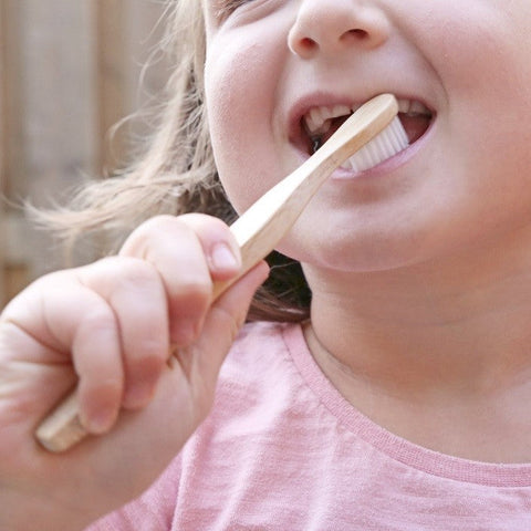 a child using a bamboo toothbrush withs soft bristles from beewise amsterdam