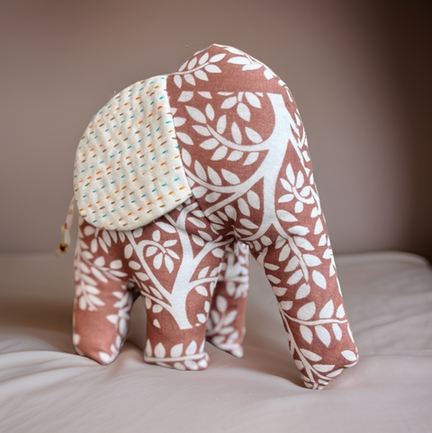 Fabric elephant with leaf pattern on a neutral background