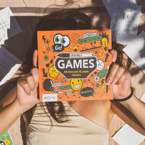 Girl showing MOYY erasable game box