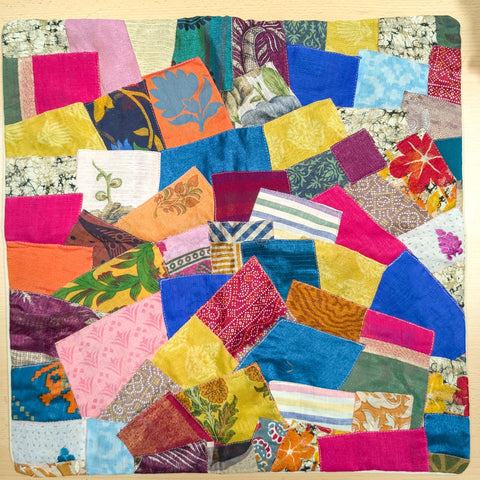 Sari patchwork cushion cover laying flat on a wooden surface