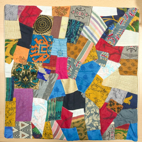 Sari patchwork cushion cover lying flat on a wooden table