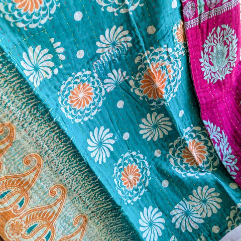 Colorful fabric with floral patterns in turquoise, orange, and pink.