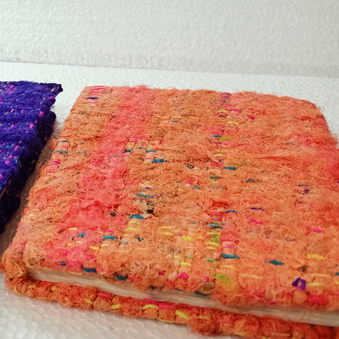 Colorful fabric notebooks on a white background