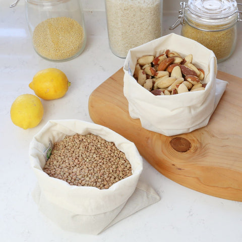 reusable produce bags made with organic cotton showing lentils and nuts being packed plastic-free