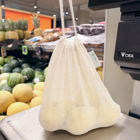 reusable produce mesh bag made in 100% organic cotton showing the mesh material on top of the scale with lemons inside in a supermarket Albert Heinz