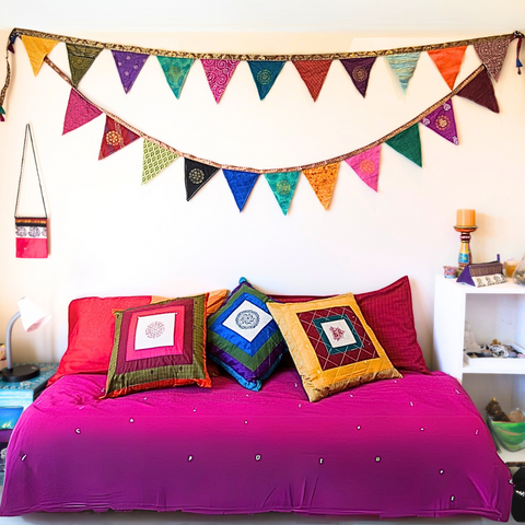 Upcycled sari flags hung above bed