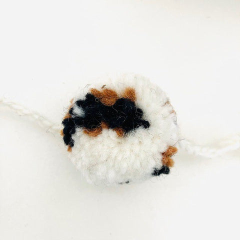 Luna-Leena slinger pom pom Leoapard - gebroken wit, bruin zwart - wol - hand gemaakt in Nepal